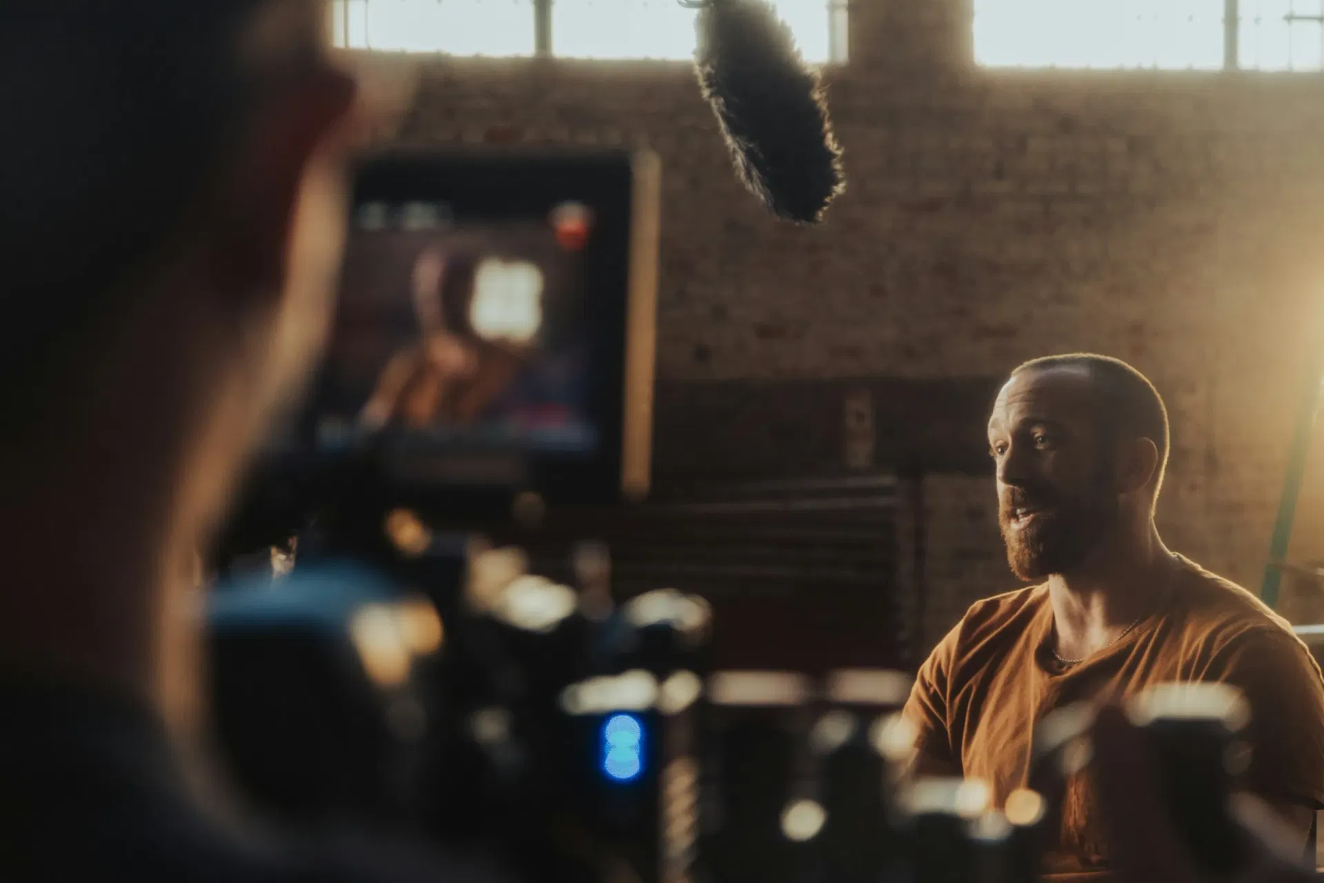 An executive interview subject framed on a cinema monitor during a brand film shoot.